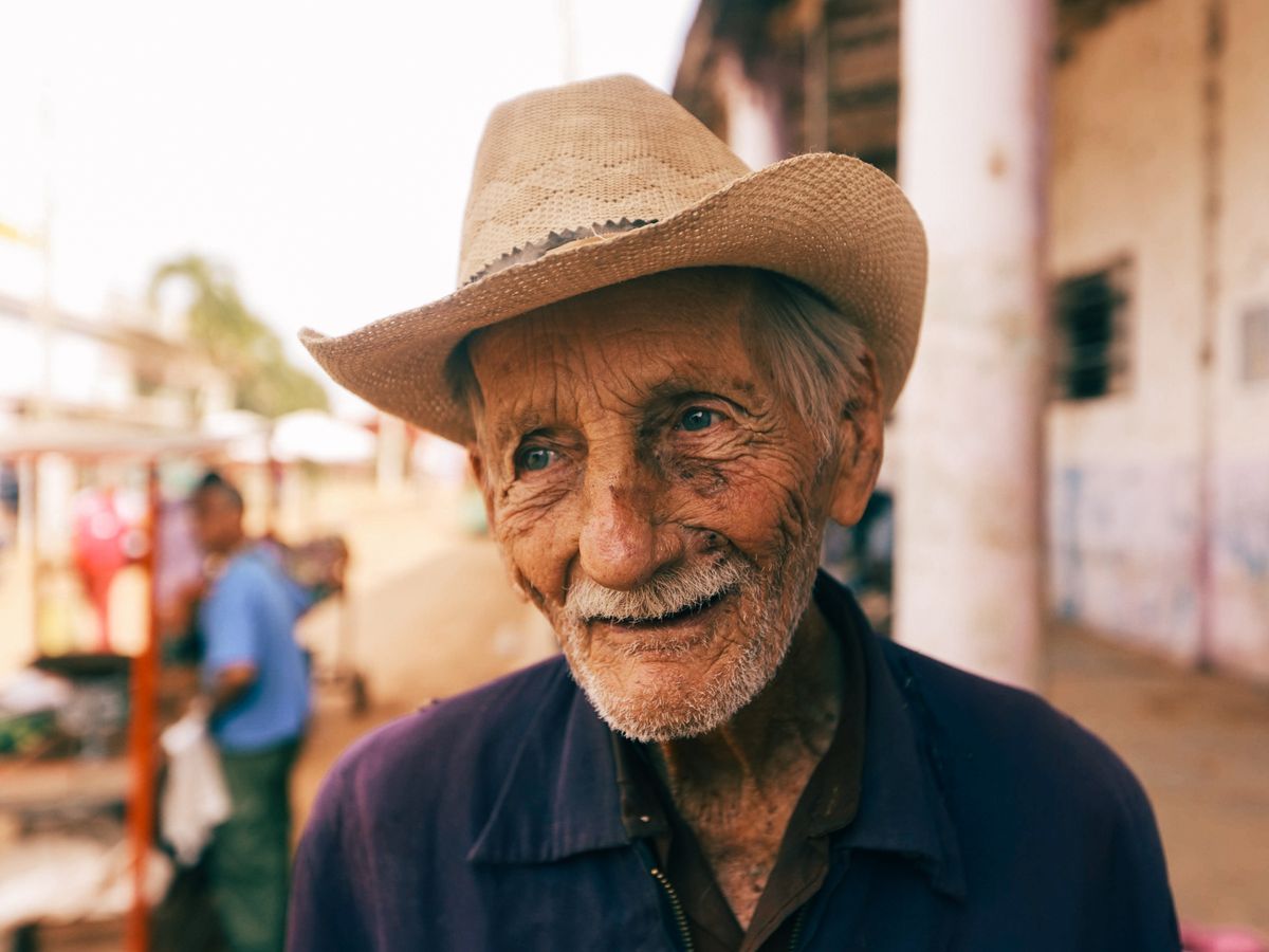 Senhor de chapéu de palha sorrindo ao ar livre